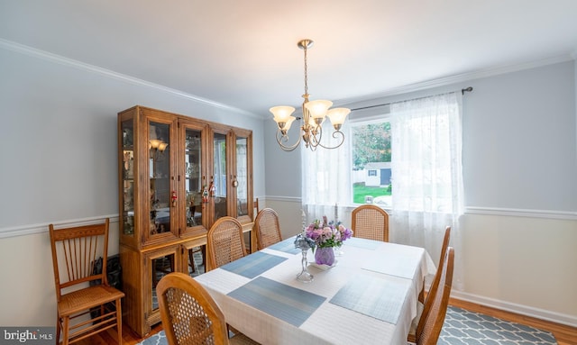 dining room featuring crown molding, baseboards, an inviting chandelier, and wood finished floors
