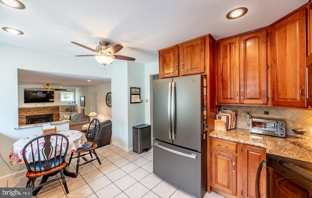 kitchen with a toaster, decorative backsplash, ceiling fan, and freestanding refrigerator