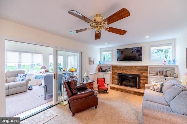 living area featuring carpet floors, ceiling fan, recessed lighting, and a stone fireplace