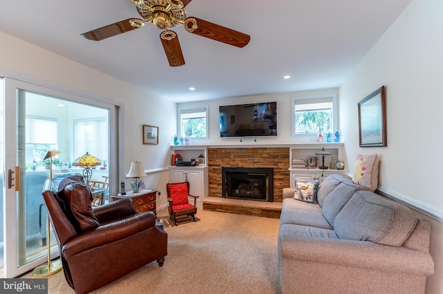 living area with recessed lighting, a ceiling fan, carpet floors, and a stone fireplace