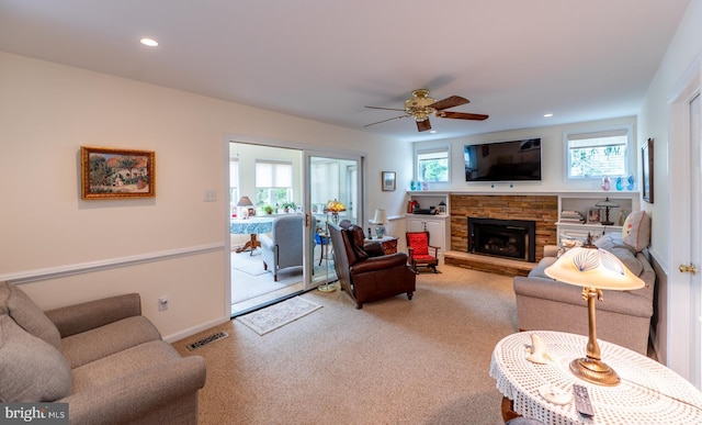 living room featuring visible vents, a fireplace, ceiling fan, recessed lighting, and light colored carpet