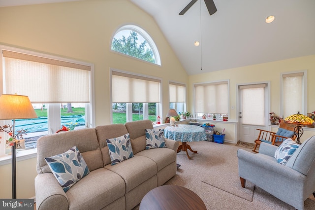 carpeted living area featuring ceiling fan and high vaulted ceiling