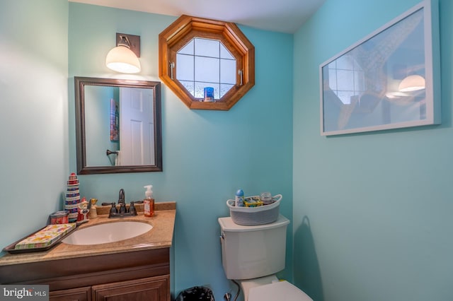 bathroom with plenty of natural light, toilet, and vanity