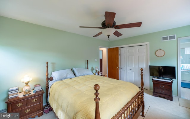 bedroom featuring visible vents, a ceiling fan, a closet, and light colored carpet