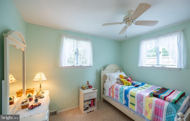 carpeted bedroom featuring baseboards, ceiling fan, and multiple windows