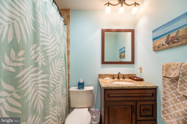 bathroom with toilet, a shower with shower curtain, and vanity