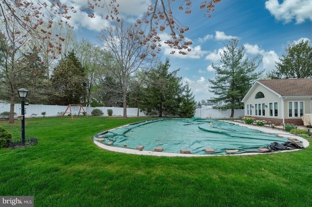 view of swimming pool with a fenced in pool, a lawn, and a fenced backyard