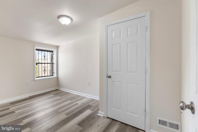 unfurnished room with wood finished floors and baseboards