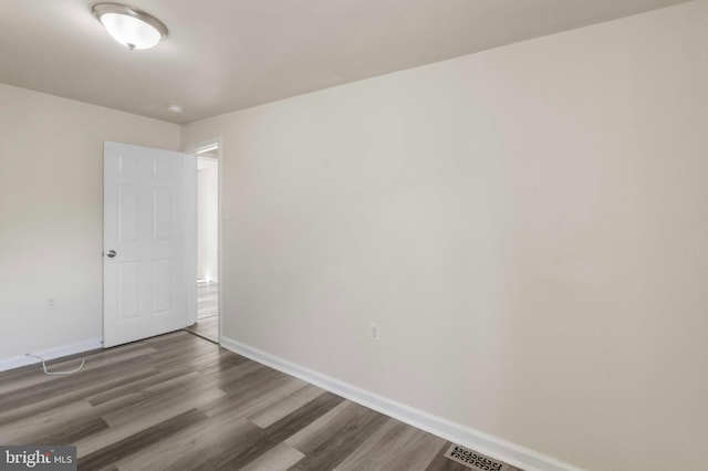 empty room featuring baseboards and wood finished floors