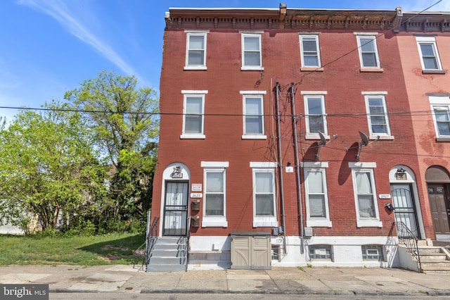 townhome / multi-family property featuring brick siding and entry steps
