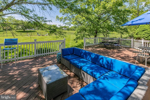 wooden terrace with outdoor lounge area, outdoor dining area, and a lawn