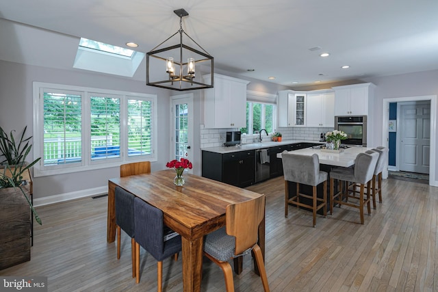173 Christopher Dr, Princeton, NJ 08540 - dining space with a chandelier, a skylight, light wood-style flooring, baseboards, and recessed lighting