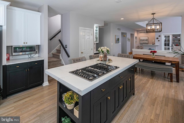 173 Christopher Dr, Princeton, NJ 08540 - kitchen with appliances with stainless steel finishes, light wood-style flooring, white cabinetry, a chandelier, and dark cabinets