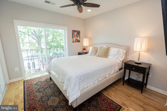 bedroom with visible vents, wood finished floors, access to outside, and multiple windows