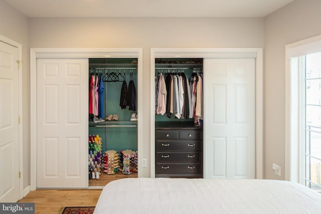 bedroom with multiple closets and wood finished floors