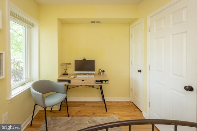 office area featuring visible vents, light wood-style flooring, and baseboards