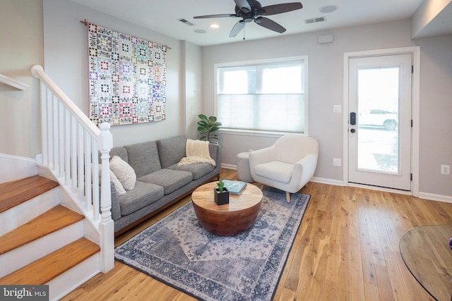 living area featuring baseboards, a ceiling fan, wood finished floors, and visible vents