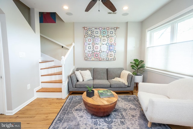 living room with a ceiling fan, light wood-type flooring, stairs, baseboards, and recessed lighting