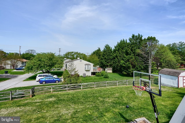 exterior space featuring a yard, fence, and a storage shed