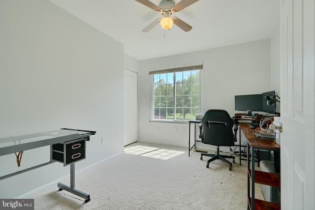 carpeted office with baseboards and a ceiling fan