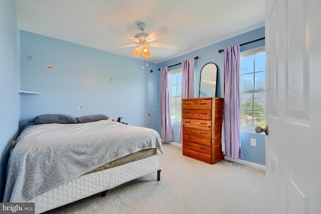 bedroom featuring light colored carpet, baseboards, visible vents, and multiple windows