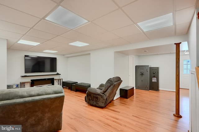 living room featuring light wood-style floors and a drop ceiling