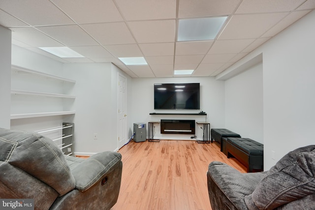 living room with a paneled ceiling and wood finished floors