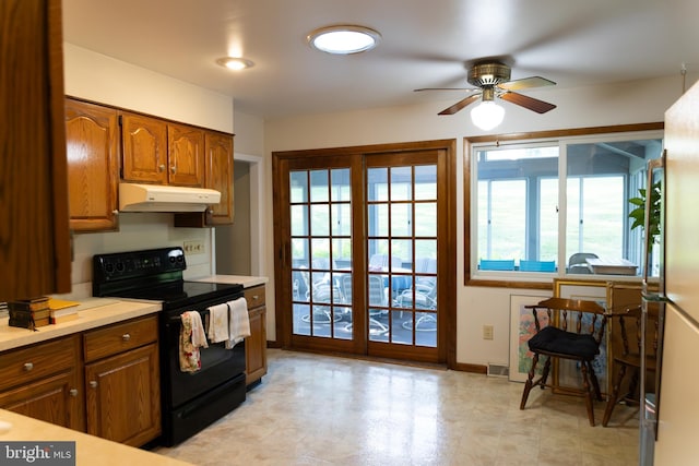 403 Leslie Ln, West Chester, PA 19382 - kitchen with electric range, under cabinet range hood, brown cabinetry, light countertops, and ceiling fan