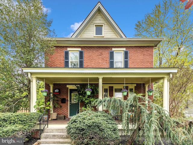 view of front of property with covered porch and brick siding
