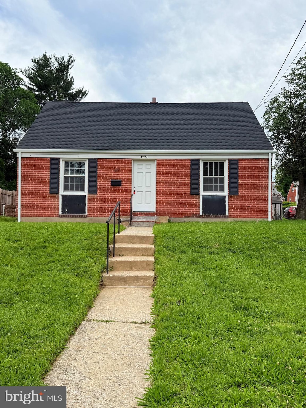3724 Cedar Dr, Baltimore, MD 21207 - view of front facade with entry steps, a shingled roof, brick siding, and a front lawn