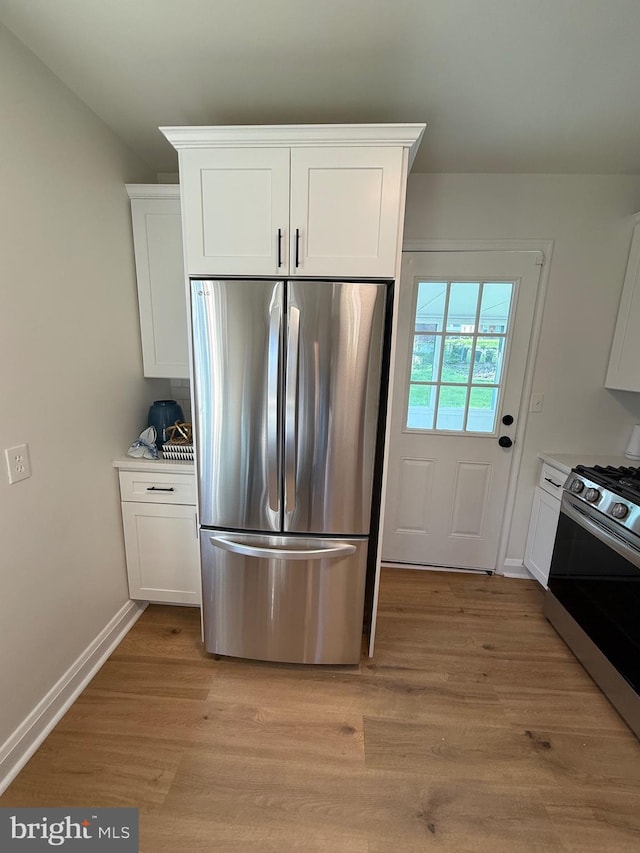 3724 Cedar Dr, Baltimore, MD 21207 - kitchen with appliances with stainless steel finishes, white cabinetry, light wood-style flooring, and light countertops