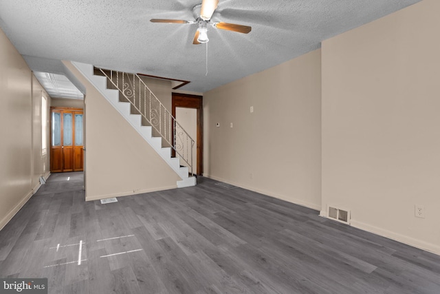 unfurnished living room featuring visible vents, a ceiling fan, a textured ceiling, and wood finished floors