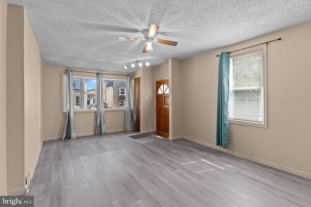 unfurnished living room featuring a wealth of natural light and wood finished floors