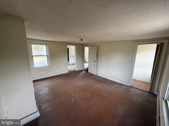empty room featuring dark wood-style floors and baseboards