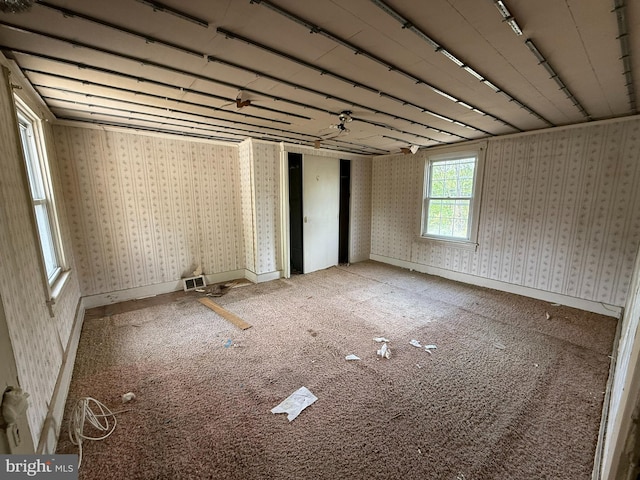 carpeted spare room with baseboards, visible vents, and wallpapered walls