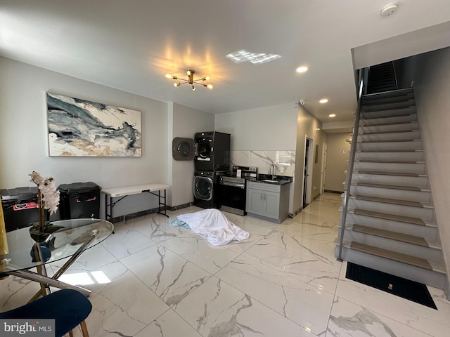interior space with stacked washing maching and dryer, recessed lighting, stairs, and marble finish floor