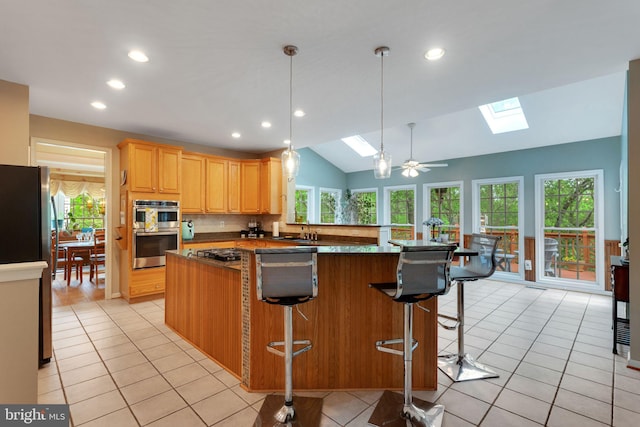 11294 Country Club Rd, New Market, MD 21774 - kitchen with a skylight, appliances with stainless steel finishes, lofted ceiling, light tile patterned flooring, and light brown cabinetry