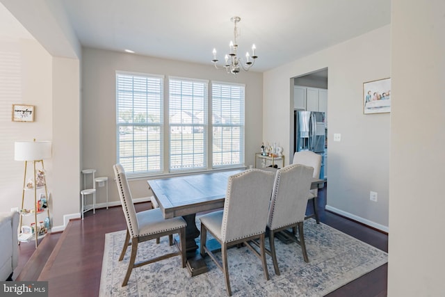 dining room with baseboards, an inviting chandelier, and wood finished floors