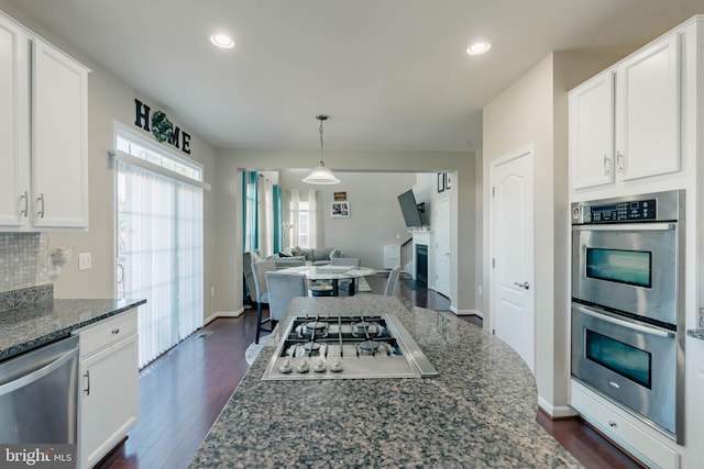 kitchen featuring dark stone counters, stainless steel appliances, dark wood finished floors, and white cabinetry