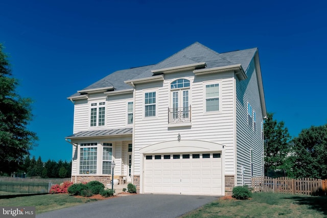 traditional-style house with a garage, aphalt driveway, fence, and stone siding