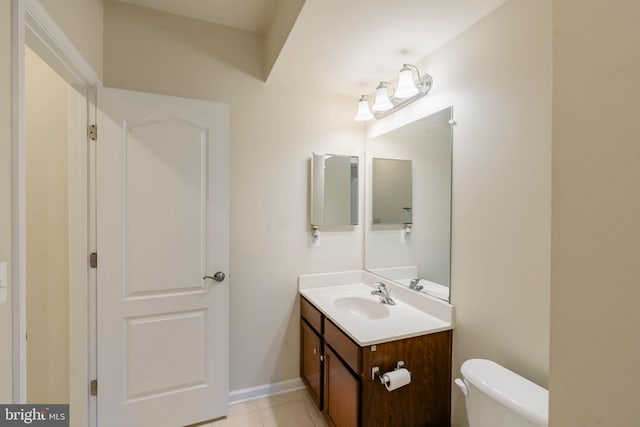 bathroom featuring vanity, tile patterned flooring, baseboards, and toilet