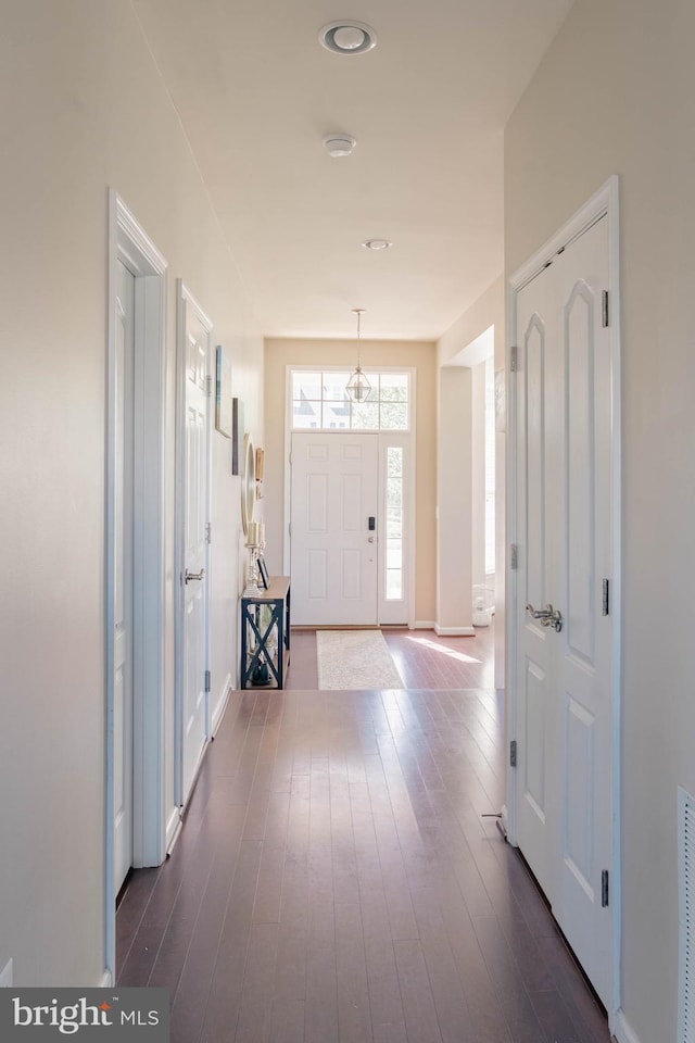 entryway with baseboards and dark wood-style floors