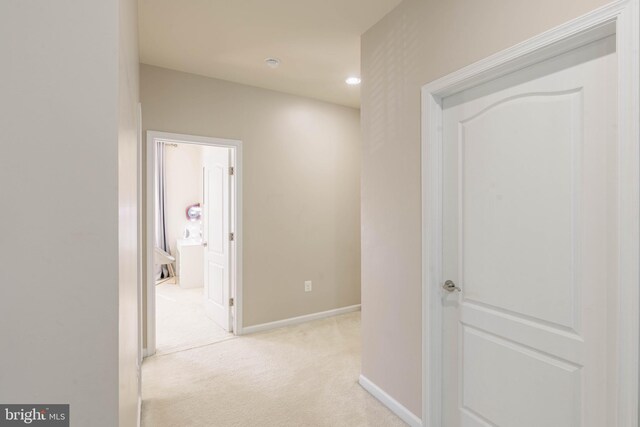 hallway featuring recessed lighting, baseboards, and light carpet