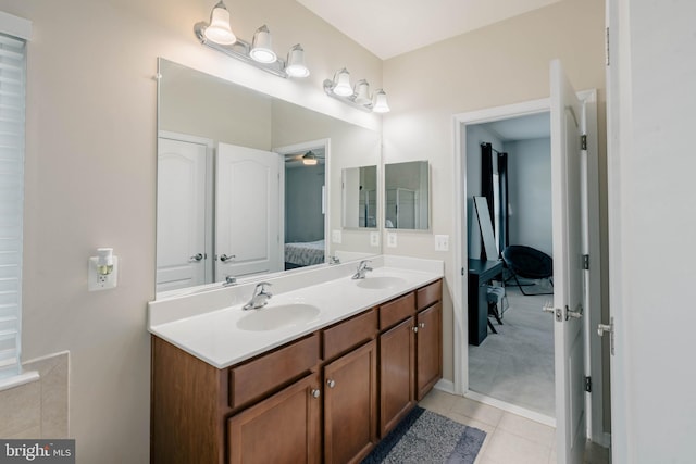 ensuite bathroom featuring a sink, tile patterned floors, ensuite bath, and double vanity