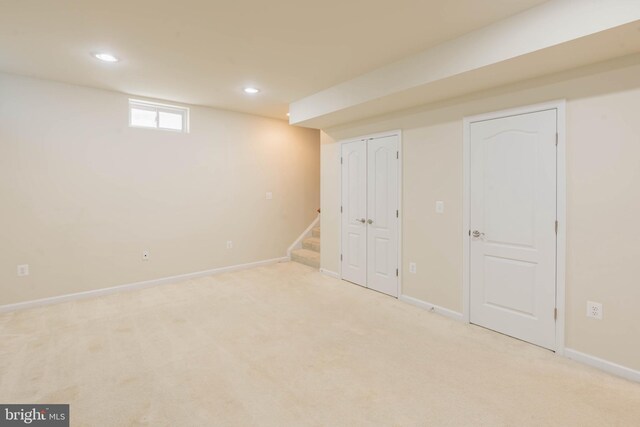 basement featuring carpet flooring, recessed lighting, baseboards, and stairway