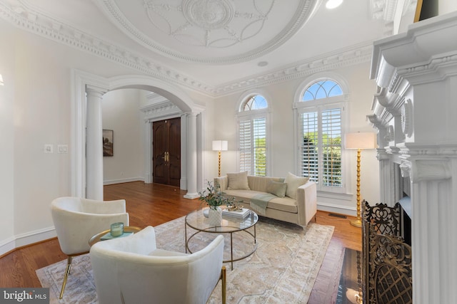 2619 Sledding Hill Rd, Oakton, VA 22124 - living room with ornate columns, a fireplace with flush hearth, arched walkways, and wood finished floors