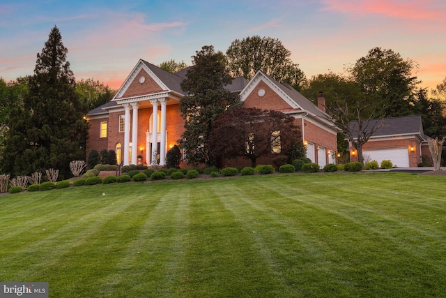 2619 Sledding Hill Rd, Oakton, VA 22124 - neoclassical / greek revival house featuring a garage, a lawn, and brick siding