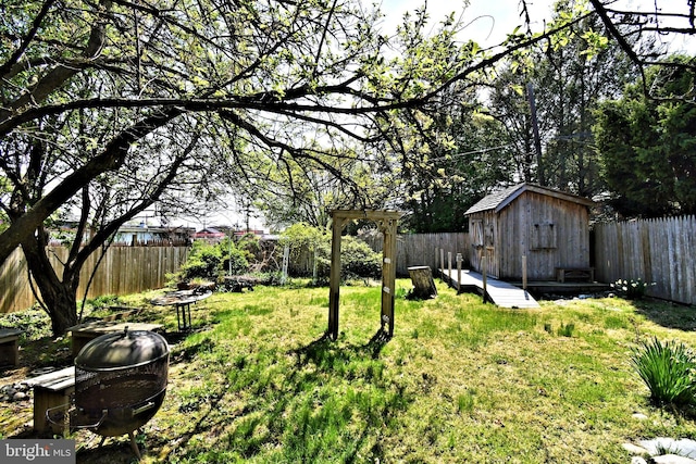 view of yard with a storage unit, an outdoor structure, and a fenced backyard