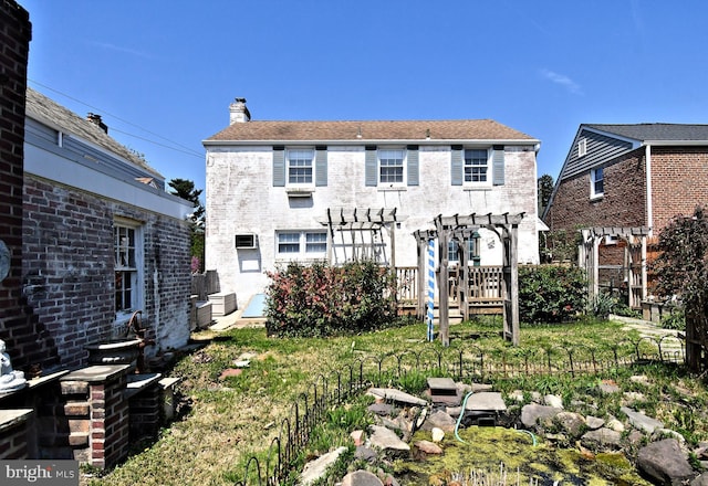 back of house with a chimney and a pergola