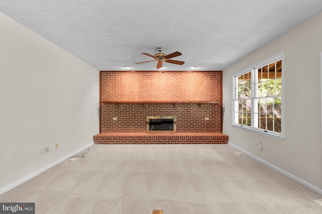 unfurnished living room featuring carpet floors, a ceiling fan, a textured ceiling, and baseboards